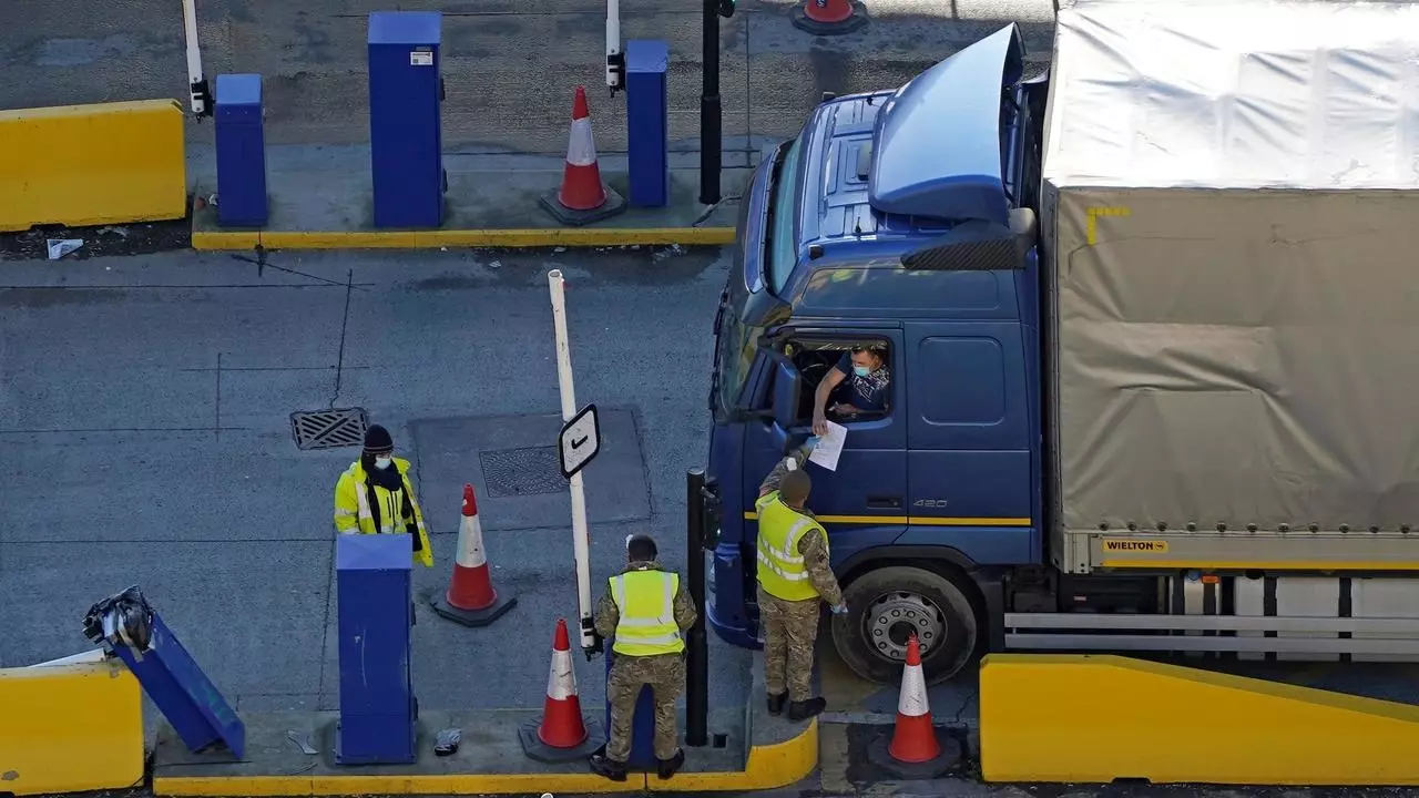 A lorry driver entering the Port of Dover on the southeast coast of England, shows his credentials to a member of the British Army  on December 25, 2020, as Covid-19 testing of drivers queueing to depart from the ferry terminal to Europe continues.