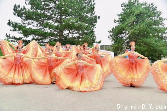 A group of women in orange dresses Description automatically generated with medium confidence