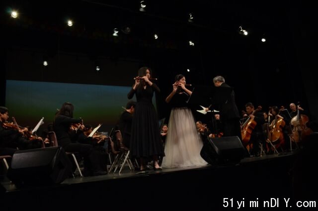 A group of people performing on a stage

Description automatically generated